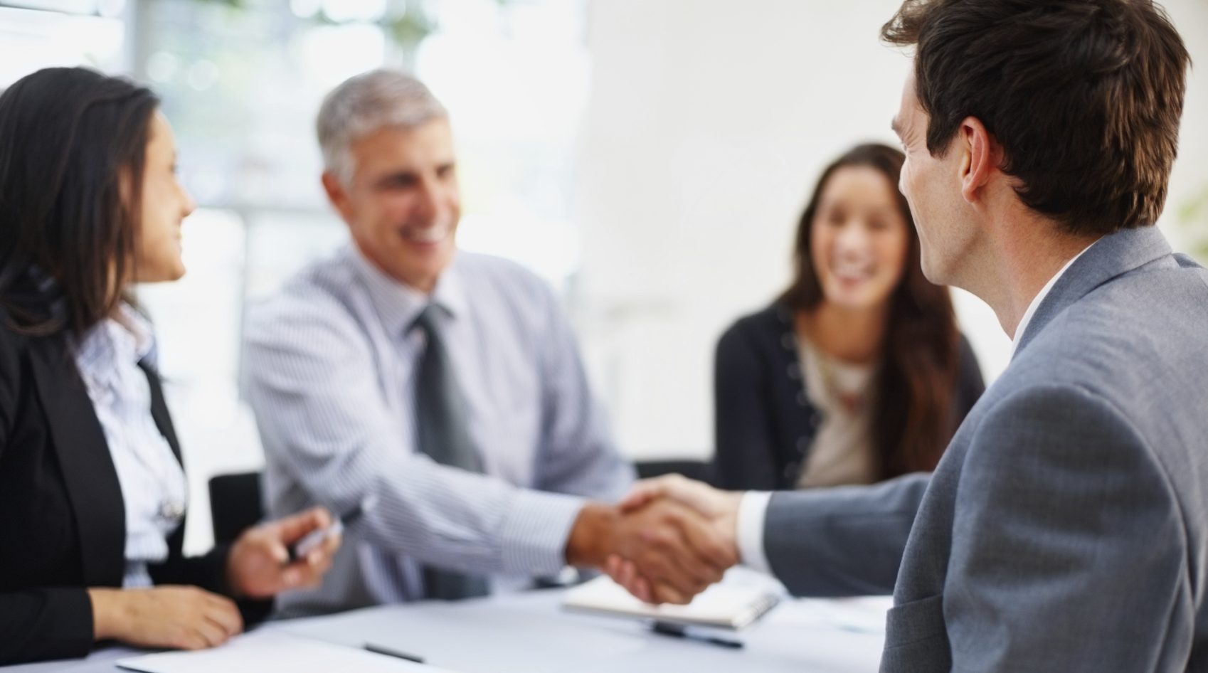 EMPLOYMENT Young business man shaking hands with senior manager in the office